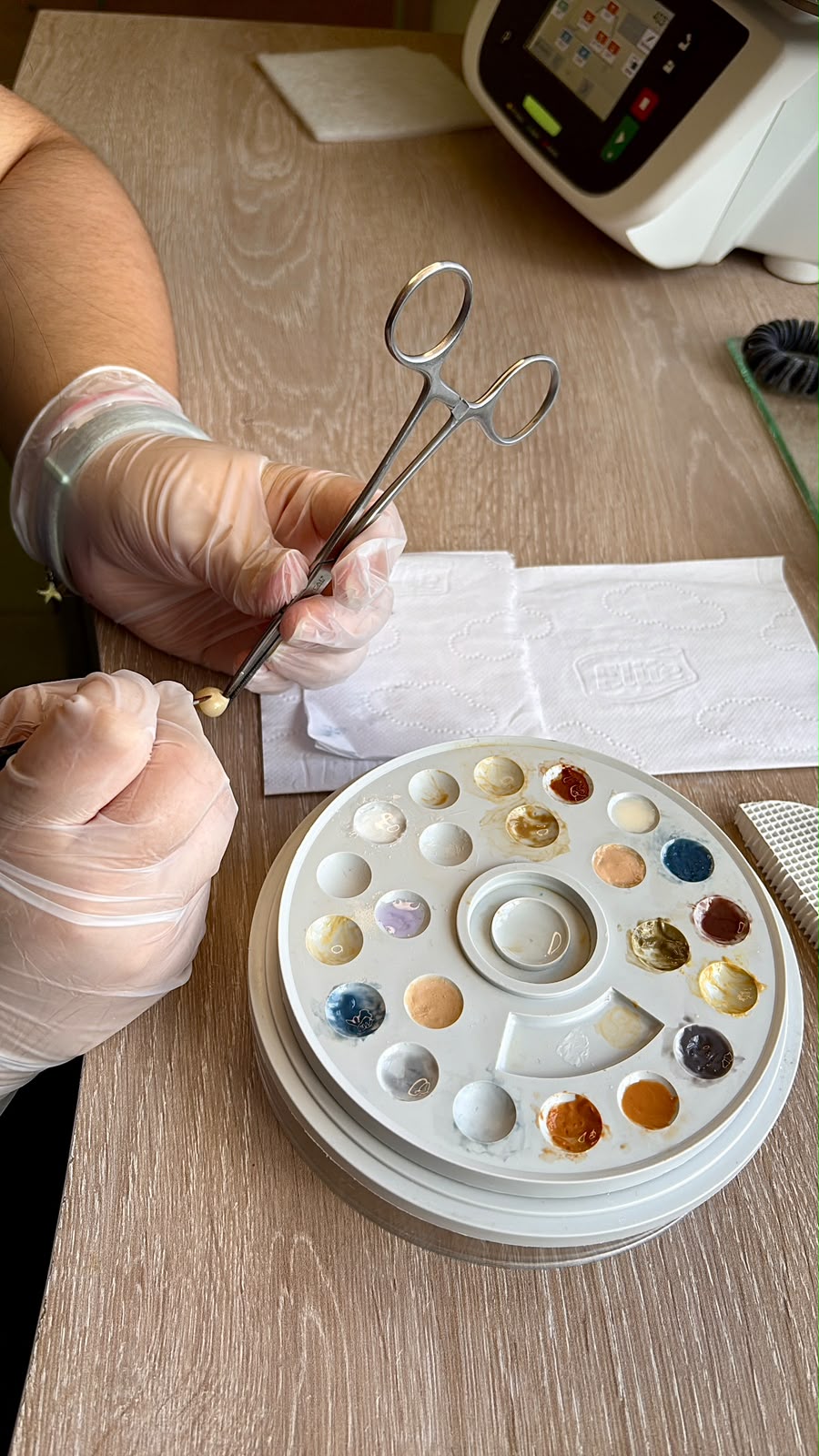 Ceramista del laboratorio caracterizando una pieza a mano con la paleta de maquillaje